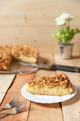 gebackener Bienenstich als Torte mit Füllung aus Creme auf Tisch aus Holz