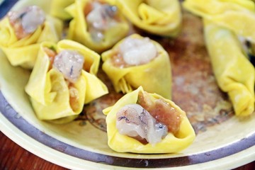 Raw home made dumplings made from shrimp and pork and wrapped by yellow flours before steam process