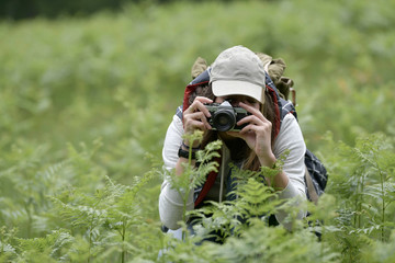 Young woman taking pictures during walk in nature