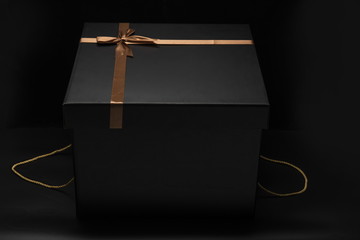 The exquisite black gift box is isolated against a black background.