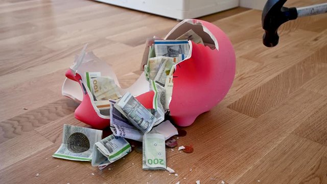 Smashing a piggy bank with a hammer, stock footage video by Brian Holm Nielsen
