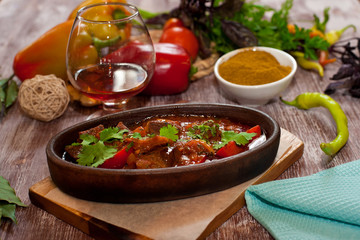 roast in a clay plate on a wooden background