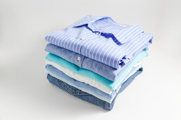 Stack of colorful perfectly folded clothing items. Pile of different pastel color shirts, sweaters...