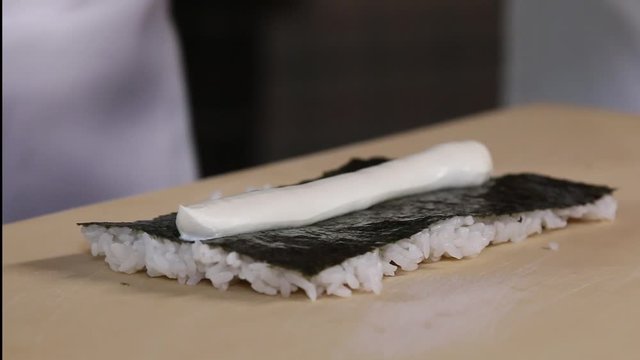 Chef's hands rolling a sushi roll. Sushi making process. Rolls the sushi roll	