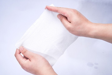 One hand picks up the paper towel and pulls, thus verifying his thickness and caprice.