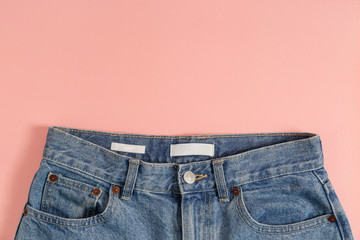 Cropped shot of a pair of buttoned mom jeans. High waisted denim pants with blank label isolated on...