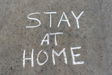 Message Stay home written on asphalt street