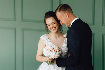 Portrait of a man and a woman nearby. Happy bride and groom embracing, smiling and having fun...