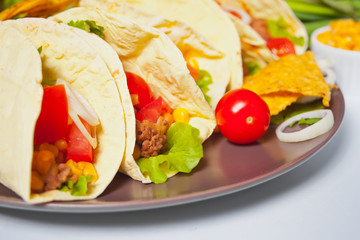 Mexican tacos with chicken meat, beans, tomatoes and corn