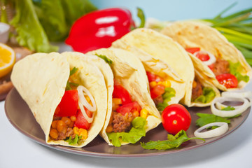 Mexican tacos with chicken meat, beans, tomatoes and corn