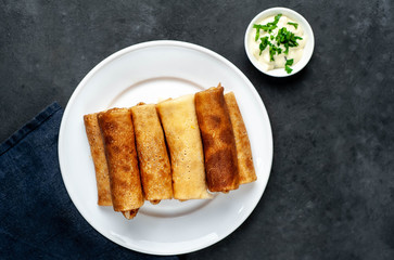 pancakes with meat on a white plate on a stone background