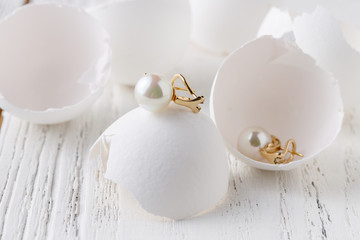 Fototapeta na wymiar white pearl jewelry on a white egg
