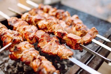 Bbq kebab grilling on open grill, outdoor kitchen. Food festival in city.