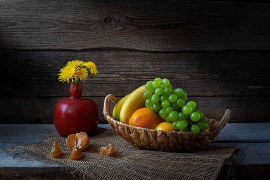 Still life from grape, bananas,orange and flowers