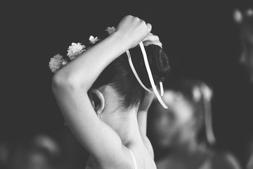 little ballerina is tying a ribbon on her head