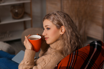 Beautiful young woman drinking hot chocolate at home