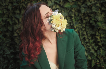 Naklejka premium Portrait of beautiful red haired woman in protective mask with flowers.
