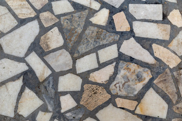 Composite floor  made of stitched together rock stones covered with compound. Background.