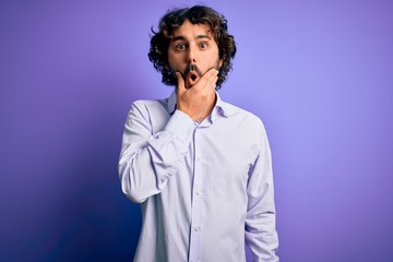Young handsome business man with beard wearing shirt standing over purple background Looking fascinated with disbelief, surprise and amazed expression with hands on chin