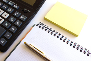 Calculator pen and notebook on white background