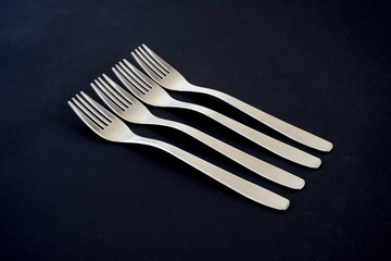 Metal forks on a black background. Suitable for mockups. Kitchen appliances.