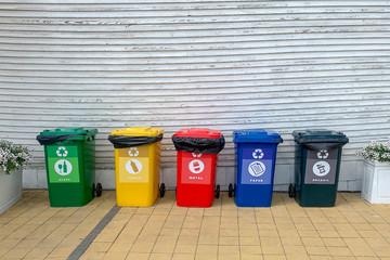 set of recycle waste bins near fence at sreet