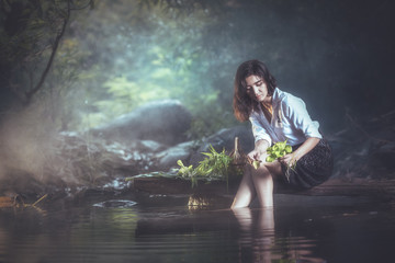 A beautiful Village woman wash vegetables at the nature river, countryside and Folkways concept - obrazy, fototapety, plakaty