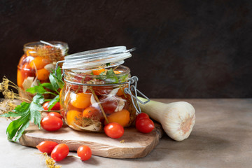 Salted cherry tomatoes in glass jar, ingredients