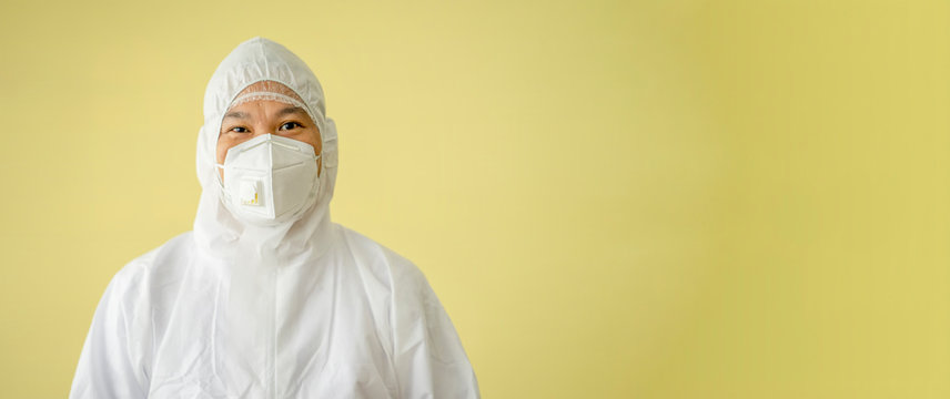 Doctor wearing personal protection equipment (PPE) and cover mouth and nose with N95 Mask with yellow background. Coronavirus disease (COVID-19) is pandemic in global.