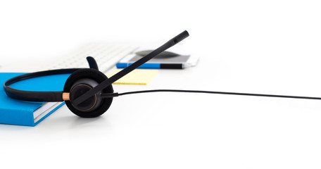 VOIP headset, pen and paper note on laptop computer keyboard. Communication support for callcenter and customer service Helpdesk. 