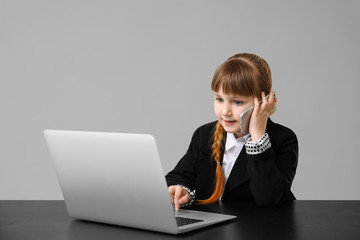 Little secretary working against grey background