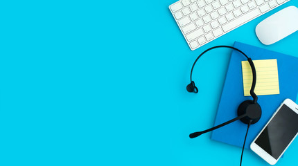 VOIP Helpdesk headset, keyboard computer notebook and mouse isolated on blue background....