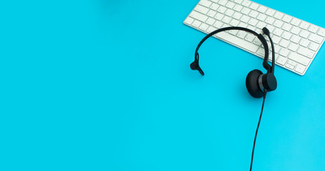 VOIP Helpdesk headset, keyboard computer notebook and mouse isolated on blue background. Communication support for callcenter and customer service Helpdesk