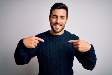 Young handsome man with beard wearing casual sweater standing over white background looking...