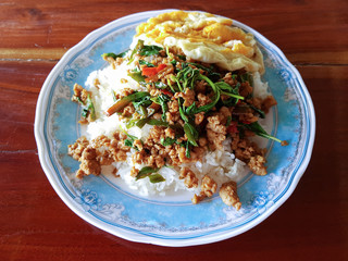 Thai food pork with basil served with rice and friend egg