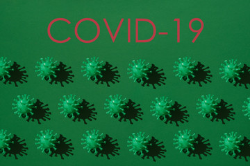 many green volumetric models of coronavirus with a hard shadow on a green  background. Concept pattern on the theme covid-19