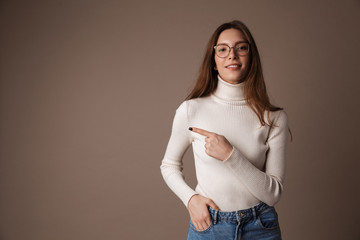 Photo of happy beautiful woman pointing finger aside and smiling