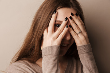 Photo of young happy woman smiling and covering her eyes