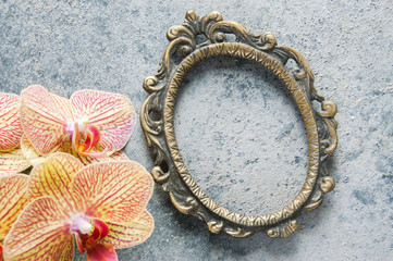 Antique brass picture frame and orchid flowers