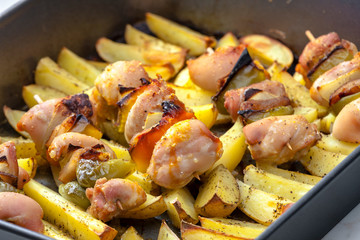 skewers with meat, onion and pepper on baked potatoes
