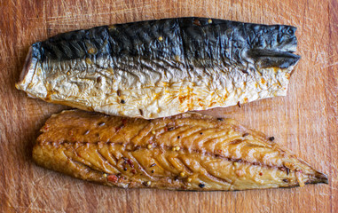 Smoked fish on a wooden plate. Kipper. Mackerel