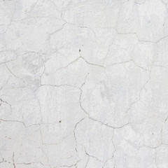 the white wall of an old house with beautiful cracks from time. white paint and whitewash on the wall. the background is white with soft blue and yellow. white old wall background