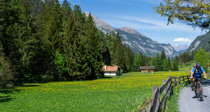 couple enjoys mountain biking in an idyllic Swiss Alps mountain landscape