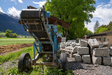 cut stones and blocks with an old rock cutting machine in the background