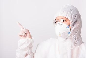 Fototapeta premium Asian female woman doctor or nurse in PPE uniform and gloves wearing face mask protective in the laboratory pointing finger to side space, Health medical coronavirus or COVID-19 concepts
