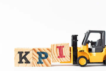 Toy forklift hold wood letter block I to complete word KPI (Abbreviation of Key performance...