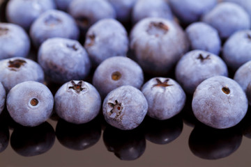 Blueberries close-up on a black mirror background