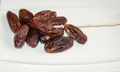 Dryed Dates on a white plate.