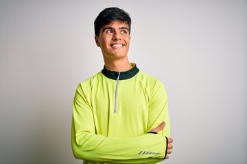 Young handsome sportsman doing sport wearing sportswear over isolated white background looking away to side with smile on face, natural expression. Laughing confident.