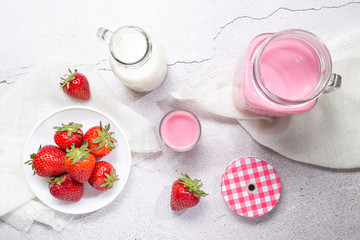 Obraz na płótnie Canvas Strawberry Milk Shake Pitcher, strawberries and milk on white background. Top view.